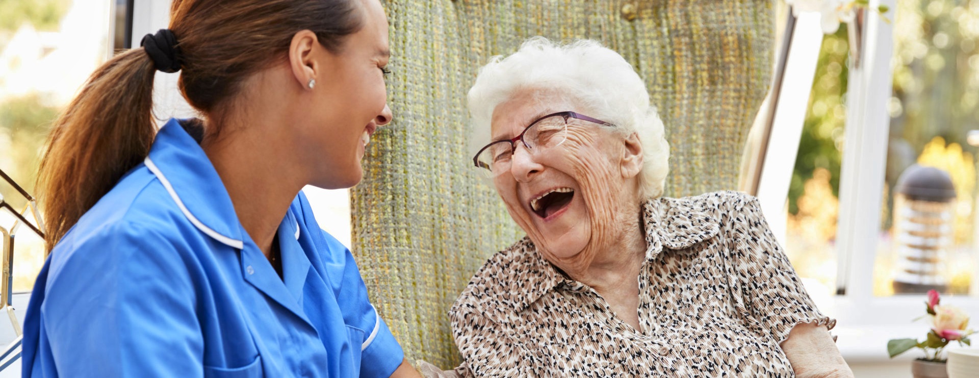 senior woman and her caregiver smiling